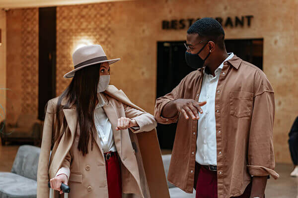 Two people communicating while practising safe contact with an elbow high five