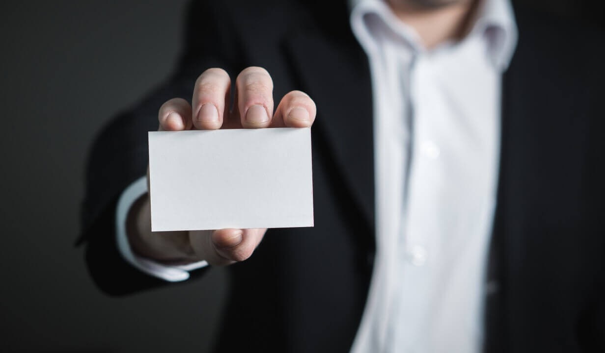 Person holding blank business card to camera